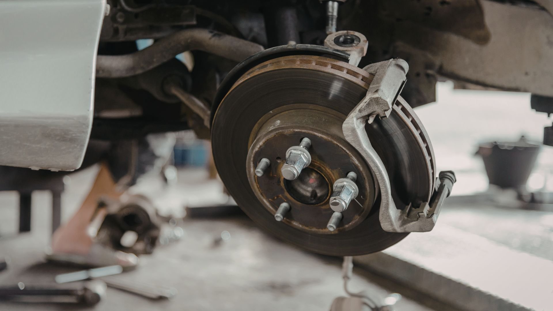 Car brake disc and caliper during automotive repair or maintenance